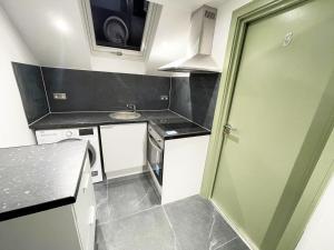 PinnerLetzi Private En-Suite In Harrow的一个带绿门和柜台的小厨房