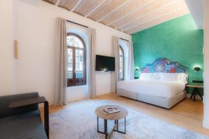 塞维利亚Cavalta Boutique Hotel GL的卧室配有白色的床和绿色的墙壁