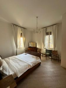 博洛尼亚Via Creti & Via Mazza Rooms的一间卧室配有一张床、一张桌子和两个窗户