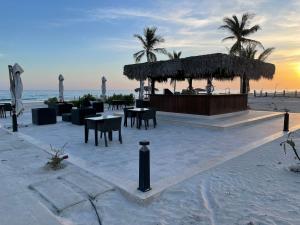 塞拉莱Palm House的海滩上带桌椅的海滩酒吧