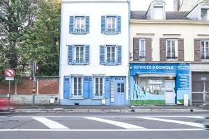 特鲁瓦Le Duplex Troyen - 5 min Hypercentre - Ideal Groupe - Parking Gratuit的城市街道上的一座蓝白色建筑