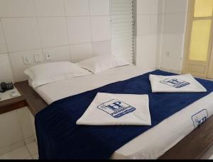 贝伦HOTEL PRESIDENTE的客房内的两张床和毛巾