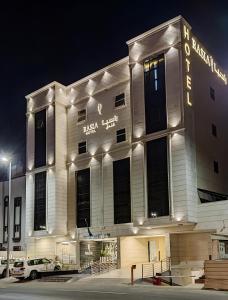 吉达Rasia Hotel Jeddah的一座白色的大建筑,晚上有灯