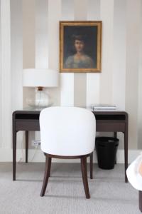 图尔儒勒豪宅酒店的一张带照片的桌子旁的白色椅子