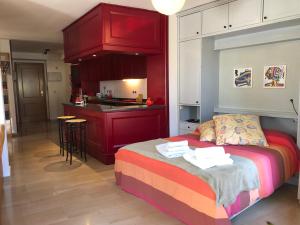 韦斯卡Loft acogedor con terraza y parking en el centro的一间带红色床的卧室和一间厨房