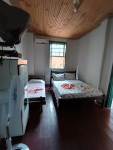 卡舒埃拉Pousada do Guerreiro的客房设有两张床和风扇。