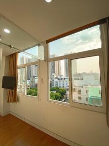 胡志明市Aloha House Apartment的客房设有2扇窗户,享有城市美景。