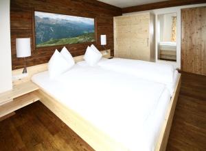 玛丽亚普法尔祖姆格拉尼兹酒店的一张白色大床,位于带木墙的房间