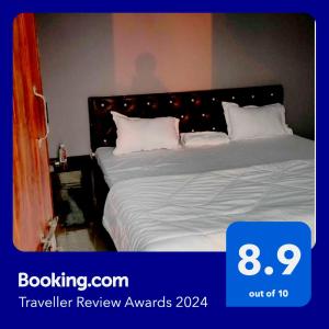 戈勒克布尔SPOT ON Hotel Paradise Inn的一间卧室配有带白色床单和枕头的床。