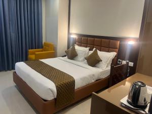 海得拉巴Hotel Landridge - HITECH City Hyderabad的一间卧室配有一张大床和一张黄色椅子