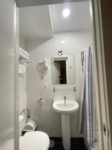 马德里奥利弗旅馆的白色的浴室设有水槽和卫生间。