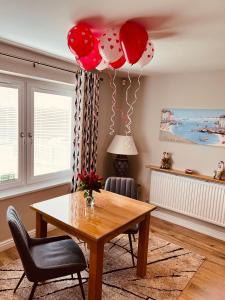 WellowPoppy Annex的一间设有桌子和红色及白色气球的用餐室