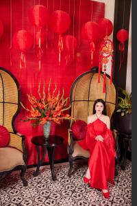 顺化Thuy Duong Boutique Hotel Hue的坐在房间里穿着红色衣服的女人