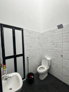 瓜拉雪兰戈One Mama’s Guest House的浴室配有白色卫生间和盥洗盆。