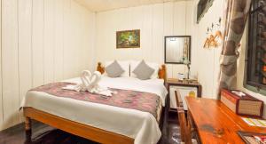 That PhanomSangthong Heritage hotel โรงแรมแสงทองเฮอริเทจ的一间卧室配有一张床,床上有毛巾