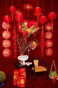 顺化Thuy Duong Boutique Hotel Hue的红色的房间,配有红色的灯、桌子和花瓶