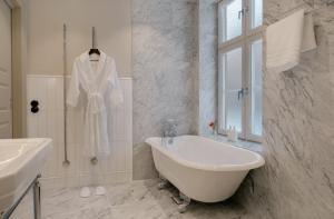 斯德哥尔摩Clas på Hörnet的白色的浴室设有浴缸和水槽。