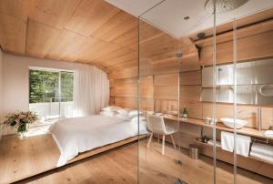 瓦尔斯House of Architects的一间卧室设有一张床和玻璃墙