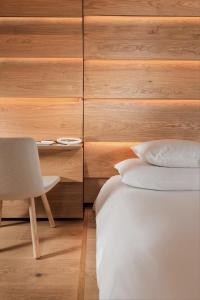 瓦尔斯House of Architects的卧室配有1张床、1张桌子和1把椅子