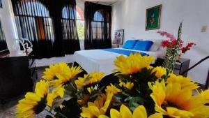 戴维HOTEL OCCIDENTAL David Chiriqui的一间卧室,配有一张床和一束黄色的鲜花