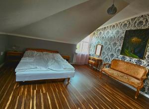 布达佩斯疗养别墅的一间卧室配有一张床和一张沙发
