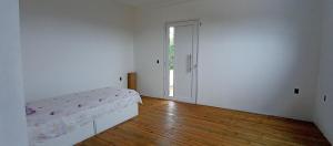 托雷斯Chalé em Torres Recanto Estelar的白色客房 - 带床和木地板