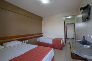 乌贝兰迪亚阿波罗酒店的酒店客房,设有两张床和镜子
