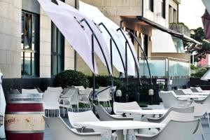 维拉加尔西亚·德·阿劳萨Hotel Alda Carril的一排带遮阳伞的白色桌椅