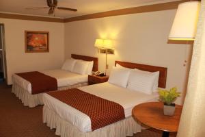 Camargo圣达菲酒店的酒店客房设有两张床和一张桌子。