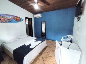 博西坎加Pousada Boiçucanga a 30m da praia的一间卧室设有两张床和蓝色的墙壁