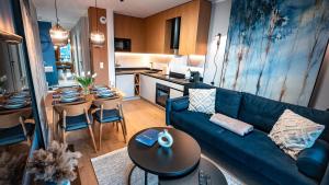 克雷尼察Apartamenty Sun & Snow Cicha的一间带蓝色沙发的客厅和一间厨房