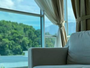 太平Comfy 2 Bedder Retreat Homestay near Taiping Lake Garden with Netflix的一张沙发,坐在大窗户前