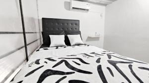 三宝垄Kost Harian Semarang Murah的白色客房内的一张黑白床