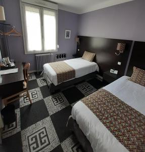 勒芒夏尔乐敦酒店的酒店客房设有两张床和窗户。