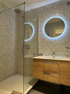 巴黎里特雷吉纳酒店的带淋浴、盥洗盆和镜子的浴室
