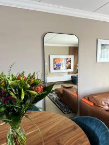 ChartwellWhite Orchid Luxury Apartment的客厅配有桌子和镜子
