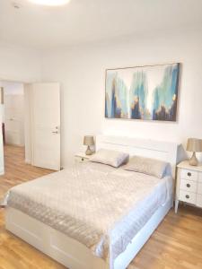 考纳斯Luxury Central Apartment Easy Kaunas的卧室配有一张床,墙上挂有绘画作品