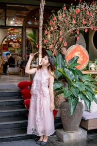 岘港Seahorse Han Market Da Nang Hostel by Haviland的穿着粉红色衣服吃水果的小女孩