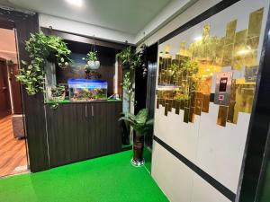 孟买Hotel the pacific Chakala的一间绿色的客房和一扇种植了植物的门