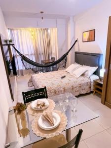大坎皮纳Ap standard confort bem localizado的一间设有床和一张带盘子及眼镜的桌子的房间