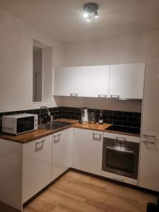 圣旺*Appartement Moderne/2 minutes du métro*的厨房配有白色橱柜、水槽和微波炉