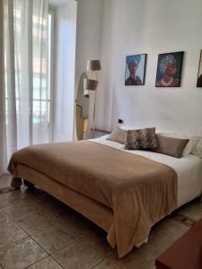 圣雷莫ALLOGGIO CENTRALISSIMO SANREMO的卧室配有一张大床,墙上挂有两张照片