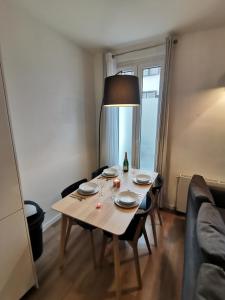 圣旺*Appartement Moderne/2 minutes du métro*的客厅里一张带盘子和台灯的桌子