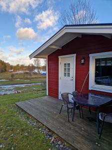 延雪平Lovsjöbadens Camping的房屋内带桌椅的木制甲板