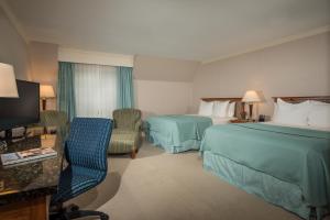 奥甘奎特Gorges Grant Hotel的酒店客房设有两张床和电视。