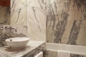 波尔图波尔图大酒店的浴室配有盥洗盆和浴缸。
