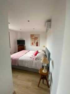 土伦Haut de villa Toulon Mourillon的一间卧室配有一张床和一张带台灯的桌子