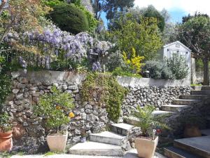 土伦Haut de villa Toulon Mourillon的石墙,有楼梯和鲜花