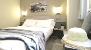 卡普多兰多Capo d'Orlando Apartments - Doria 52的一间卧室,配有一张床和一张桌子上的帽子