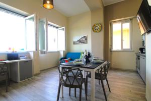 卡普多兰多Capo d'Orlando Apartments - Doria 52的厨房以及带桌椅的用餐室。